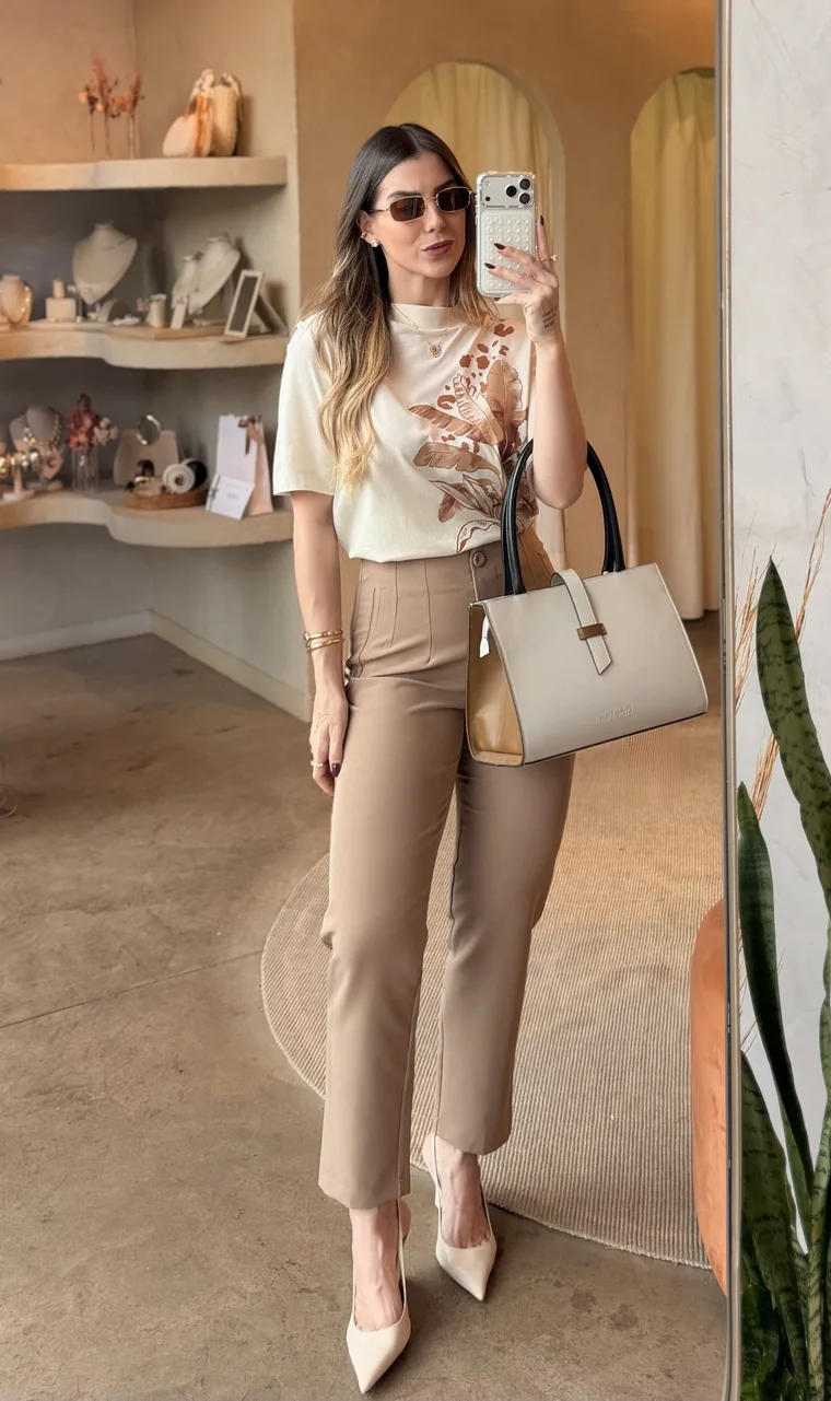 Ana Laura de blusa estampada, calça bege, bolsa e óculos escuros